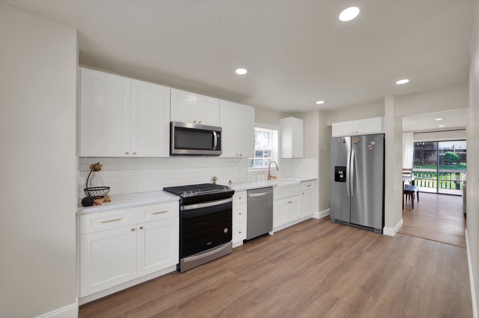 A finished kitchen renovation by Garden State ADU: white shaker cabinets, quartz counters, subway-tile backsplash and stainless appliances.